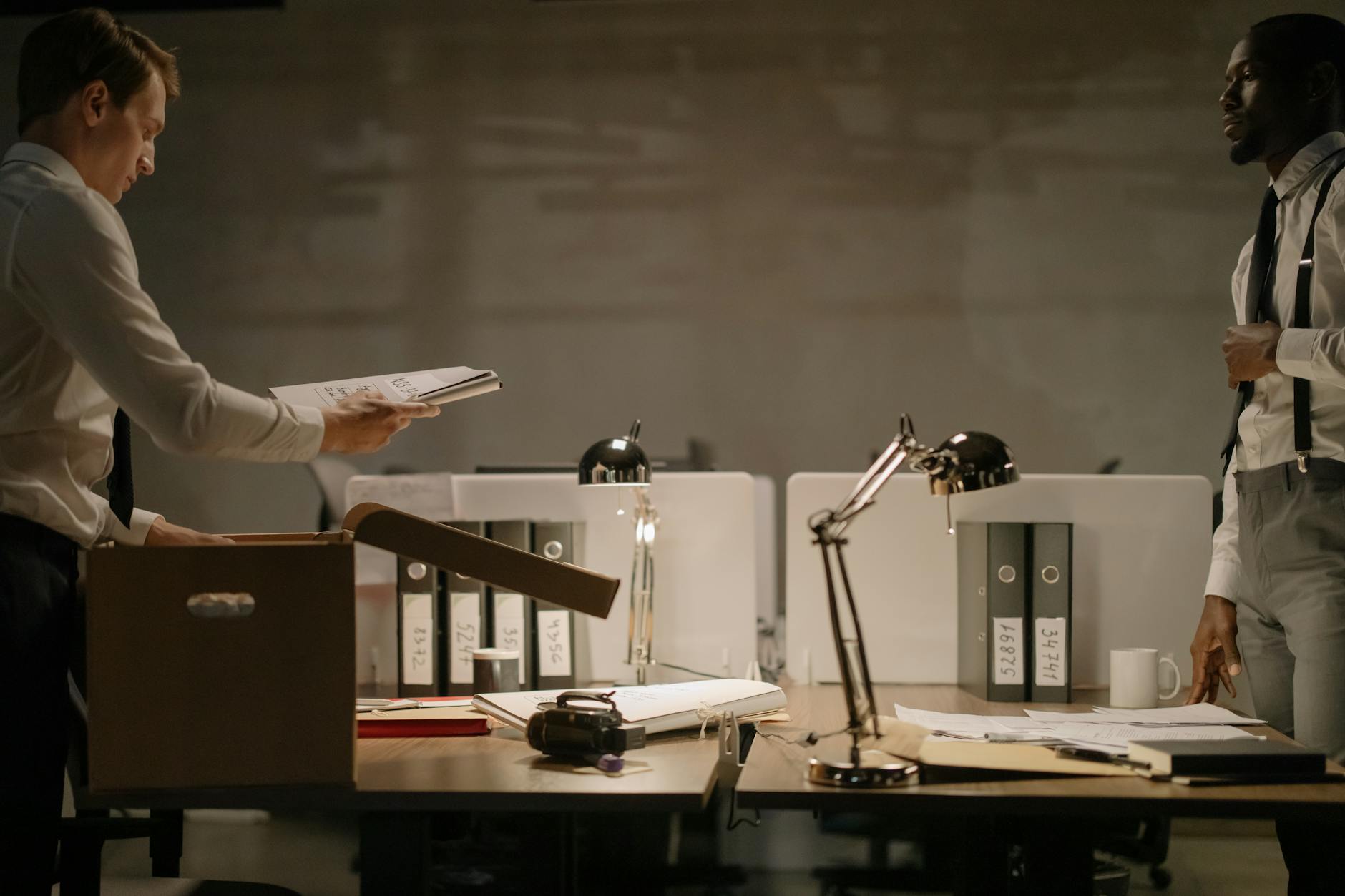 detective looking at his colleague taking out another case file