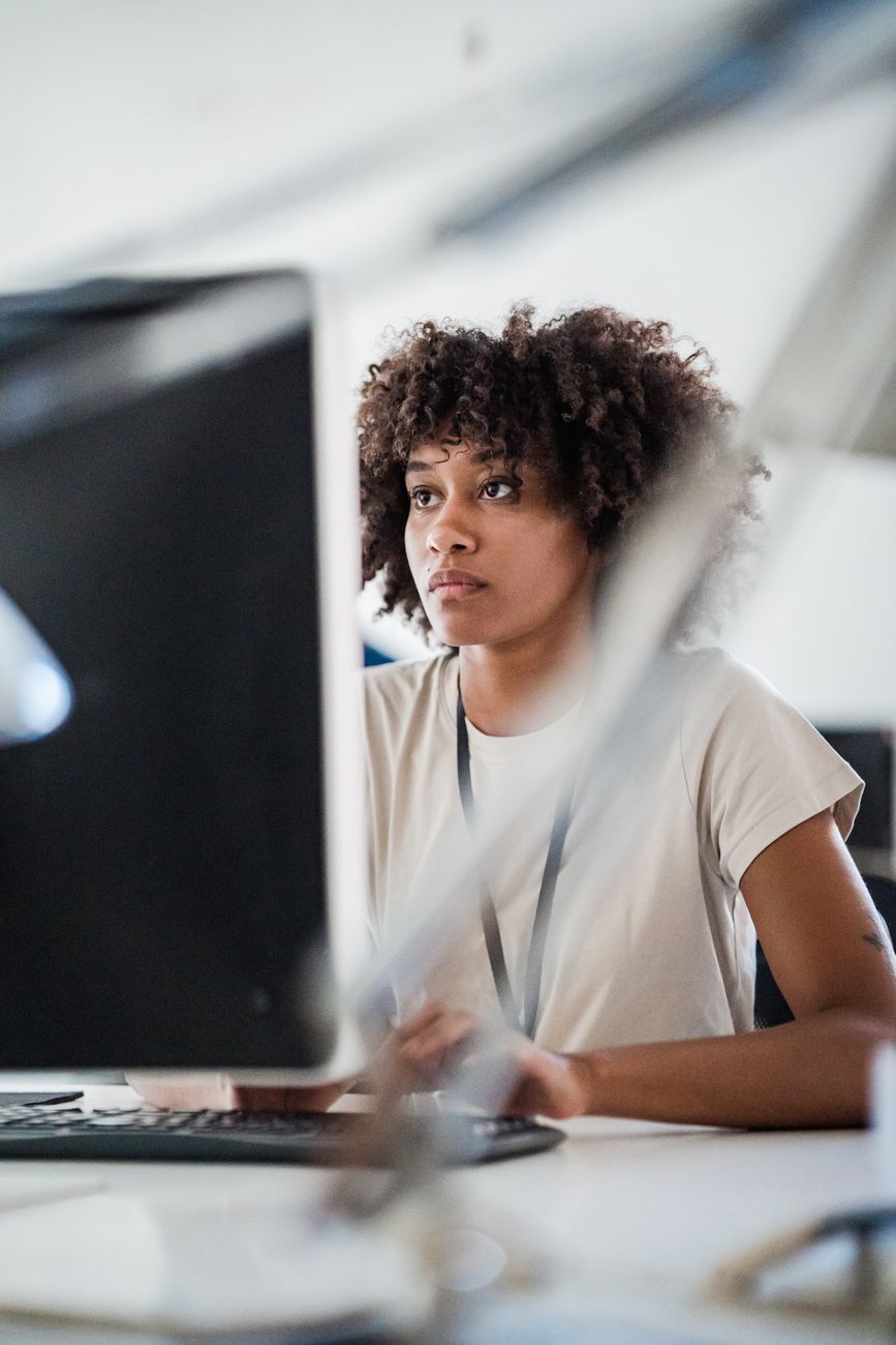 young woman looking at pc screen with attention