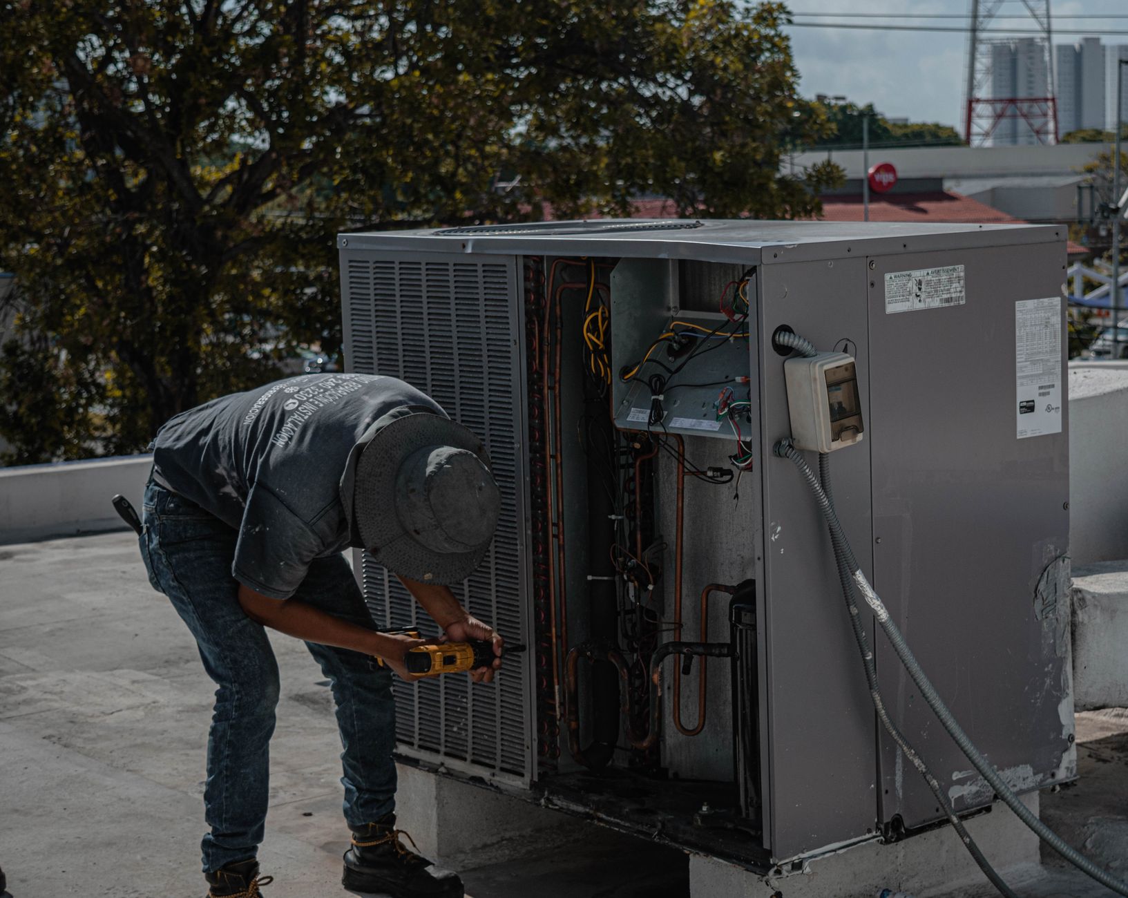 man drilling an aircon casing